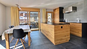 Una cucina moderna con mobili in legno, un'isola centrale e un'area pranzo con tavolo e sedie.