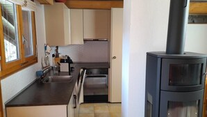 A compact kitchen with a built-in oven, a sink, and a stove.