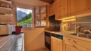 Une cuisine avec des meubles en bois, un lave-vaisselle et une fenêtre donnant sur les montagnes.