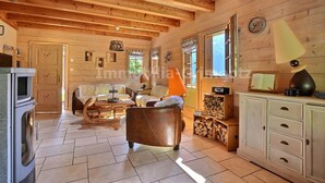 L’intérieur d’un chalet confortable, avec une cheminée, des meubles en bois et un coin repas.