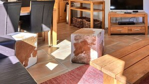 A living room with a wooden bench, a TV on a wooden stand, and a fireplace. - Very comfortable flat for 7 people, living room with wood-burner, kitchen area with dishwasher, 2 do (Grimentz)