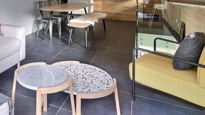 A modern living room with a grey sofa, a red cushion with a white cross, two round tables, and a yellow sofa. - Comfortable flat on 2 levels for 4 to 6 people, living room with 1 double divan bed, kitchen area wi (Grimentz)