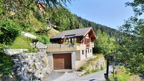 A two-story wooden cabin with a stone wall entrance, set in a mountainous area with a clear sky. - Comfortable chalet on 2 levels for 7 to 8 people, living room, kitchen area with dishwasher, 1 doubl (Grimentz)