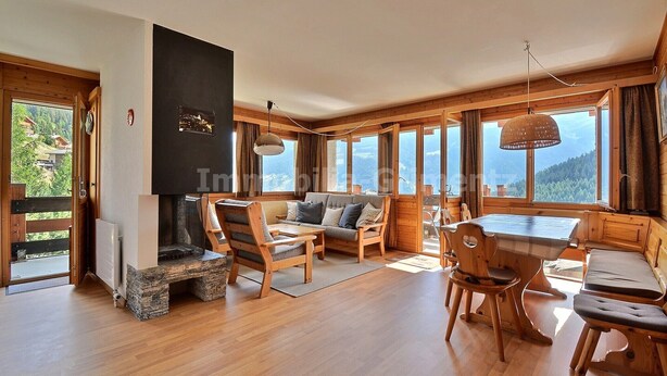A cozy cabin interior with a fireplace, wooden furniture, and large windows offering a mountain view. - Comfortable flat for 6 people, living room with fireplace, kitchen area with dishwasher, 1 2-bedroom (Grimentz)