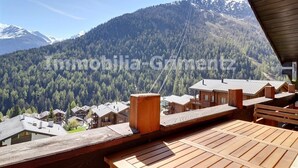 A wooden deck with a view of a mountainous landscape and a row of chalet-style buildings. - Comfortable flat on 2 levels for 6 people, living room, kitchen area with dishwasher, 1 double bedro (Grimentz)