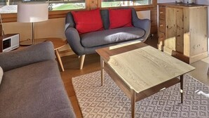 A compact living space with a sofa, a table, a cabinet, and a chair. - Comfortable flat on 2 levels for 6 people, living room, kitchen area with dishwasher, 1 double bedro (Grimentz)