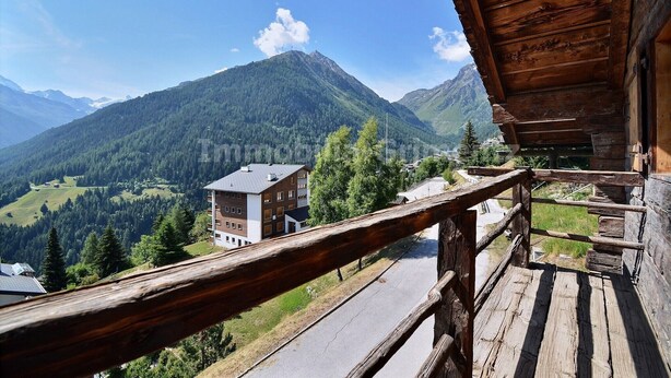A wooden balcony with a view of a mountain and a building in the background. - Comfortable traditional chalet on 2 levels for 7 to 8 people, living room, separated kitchen with di (Grimentz)