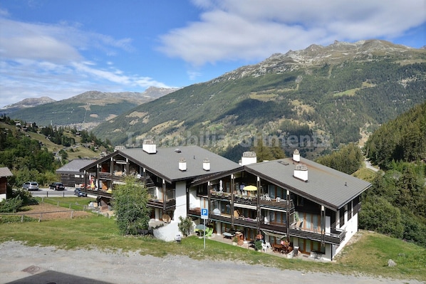 A mountain lodge with multiple balconies and a view of the surrounding mountains. - Comfortable studio on 2 levels for 2 to 4 people, living room with 1 divan bed, kitchen area with di (Grimentz)