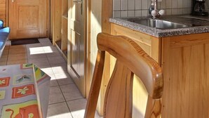 A compact kitchen with wooden cabinets, a stainless steel sink, and a built-in dishwasher.