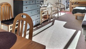 Et hyggeligt værelse med et træbord, en sofa og en seng.