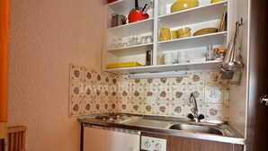Une cuisine compacte équipée d’un lave-vaisselle intégré, d’un évier et d’une cuisinière.