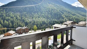 A mountain view with a ski lift, wooden buildings, and a clear sky.