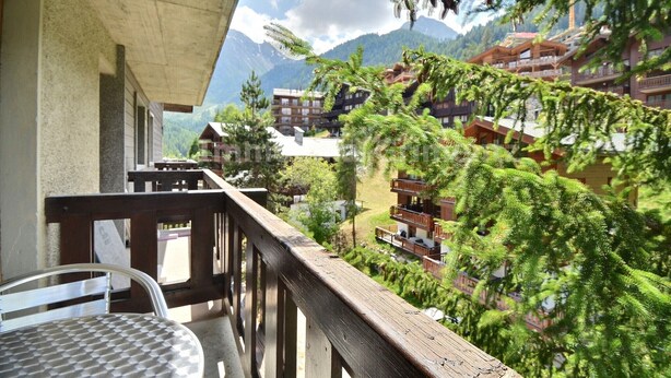 Un balcone con vista su una zona montuosa e un complesso di edifici.