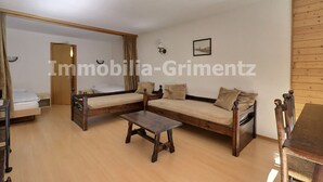 A room with a sofa set, a small table, and a bed.