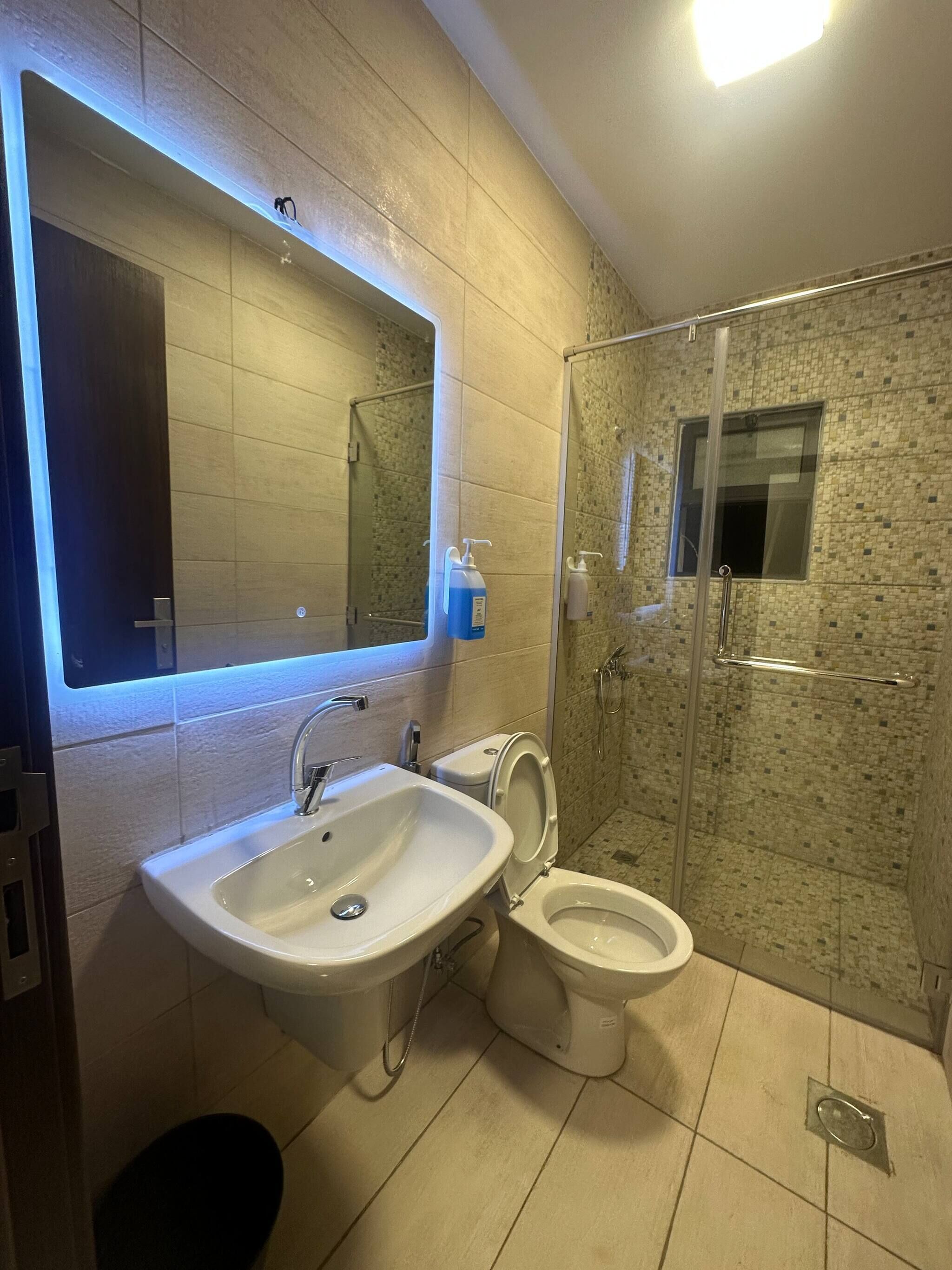 Un baño con lavamanos, inodoro y zona de ducha.