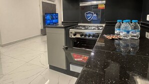 Una cocina con estufa, horno y botellas de agua sobre la encimera.