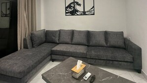 Una sala moderna con un sofá modular, una mesa de centro y una obra de arte en la pared.