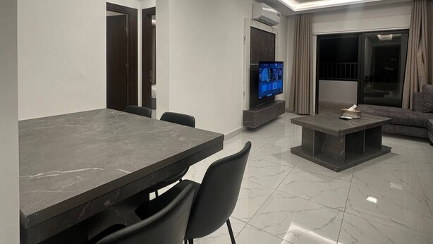 Una sala de estar moderna con comedor, televisor de pantalla plana y sofá.