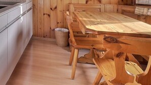 A kitchen with a built-in oven, a sink, and a wooden dining table with chairs. - Comfortable flat on 2 levels for 3 to 4 people, living room, kitchen area, 1 double bedroom (140), 1 (Grimentz)