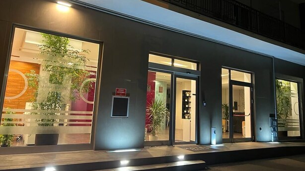 A hotel entrance with a modern design, featuring glass doors and a visible reception area. - Hotel Parnaso (Trebisacce)