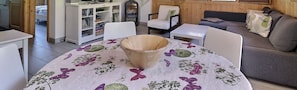 Una sala de estar acogedora con una mesa redonda, un sofá y un cuenco de madera sobre la mesa.