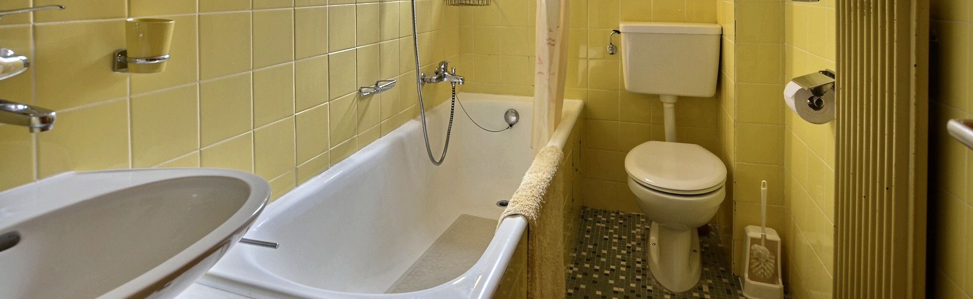 Et badeværelse med badekar, toilet og bidet.