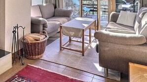 Una sala acogedora con chimenea, un sofá, una mesa y una cesta de mimbre.