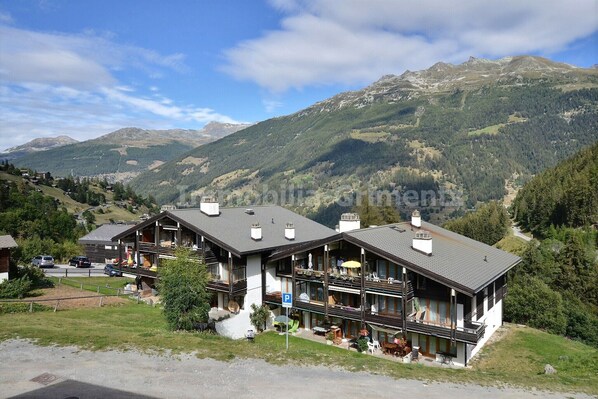 Eine Berghütte mit mehreren Balkonen und Blick auf die umliegenden Berge.