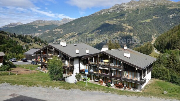 A mountain lodge with multiple balconies and a view of the surrounding mountains. - Middle class flat for 4 people, small living room with fireplace, kitchen area with dishwasher, 1 sm (Grimentz)
