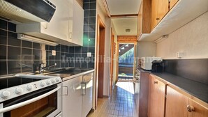 A kitchen with a stove, oven, and cabinets. - Middle class flat for 4 people, small living room with fireplace, kitchen area with dishwasher, 1 sm (Grimentz)
