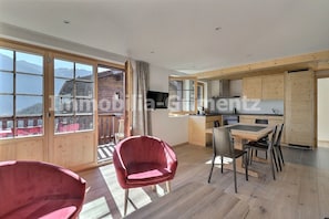 Una cocina moderna con armarios de madera y un comedor con mesa y sillas.