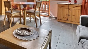 A cozy living room with a wooden coffee table, two grey sofas, and a dining area with a wooden table and chairs. - Comfortable flat on 2 levels for 4 to 6 people, living room, kitchen area with dishwasher, 1 double (Grimentz)