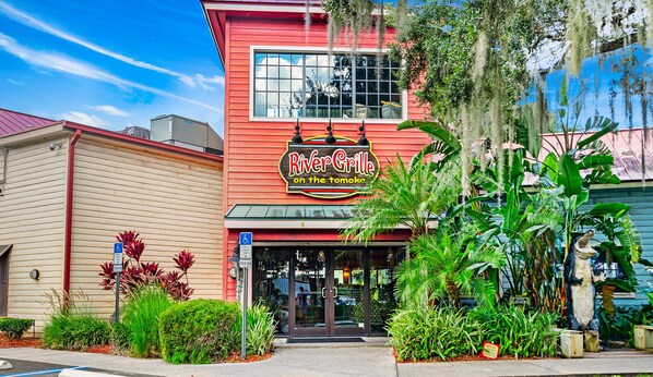 Un edificio rosso con un cartello che riporta la scritta "RiverGrille sul tomoke".