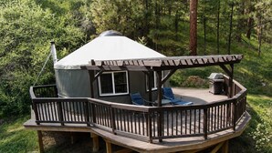 Une terrasse couverte avec des sièges d’extérieur et un espace barbecue.