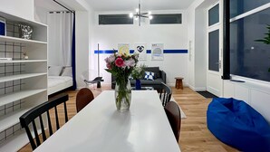 Eine moderne Küche mit weißen Schränken, einem Esstisch und einem blauen Sitzsack.