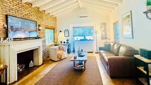 Un salon avec une cheminée, un canapé, une table basse et un téléviseur.