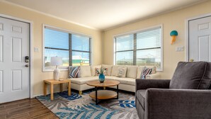 A living room with a sofa, armchair, coffee table, and a rug. - Gulf Side-Walk to the beach, great views, pet-friendly - Boa Vista (Dauphin Island)