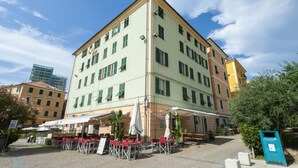 Un immeuble à plusieurs étages doté d’une terrasse et d’une cour dallée.