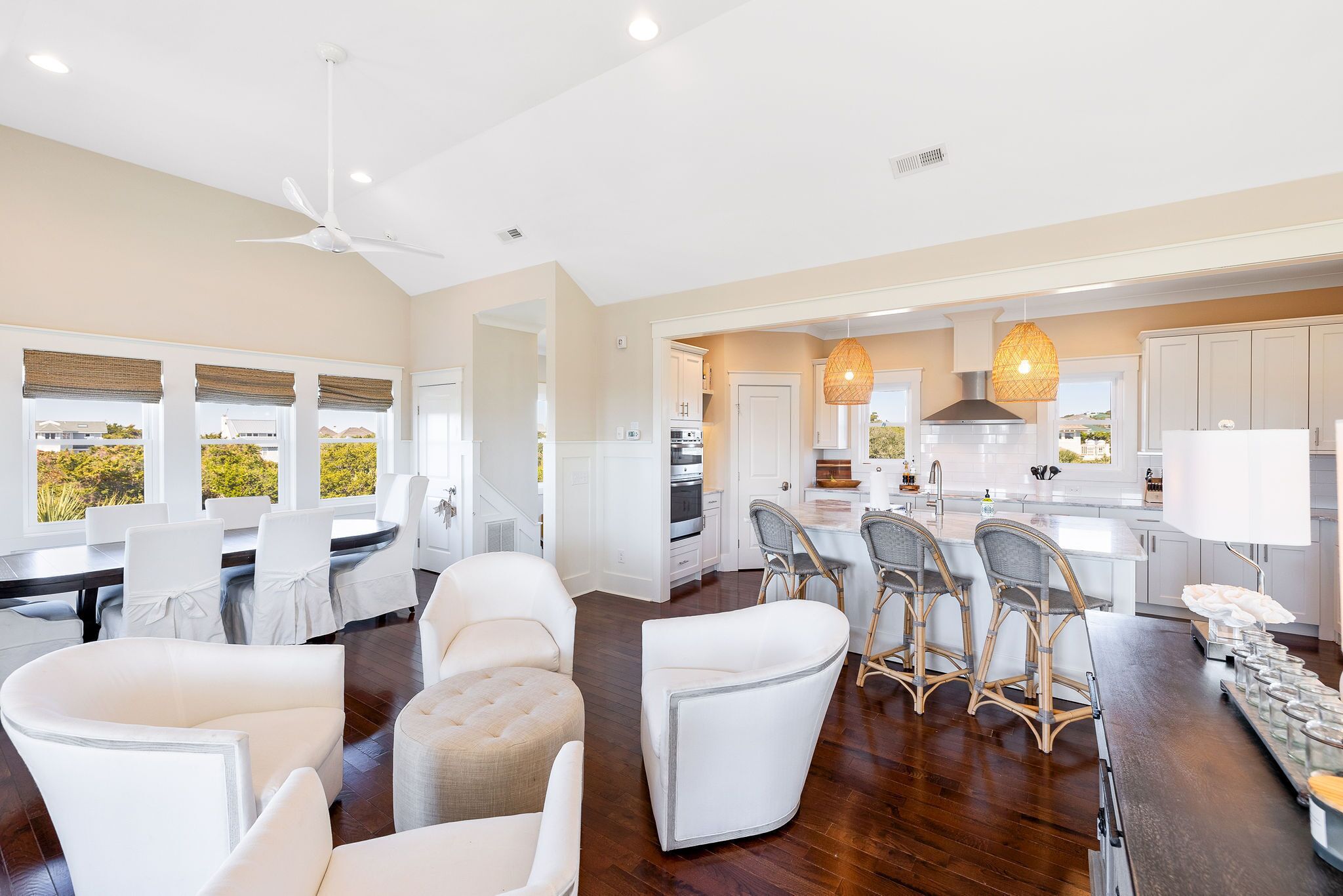 A spacious living area with a dining set, a kitchen, and a view of the outdoors.