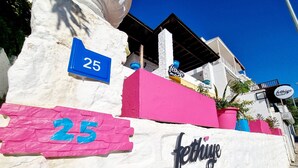 Un edificio con un letrero que dice "fethiye motel" y el número "25" en una pared blanca.