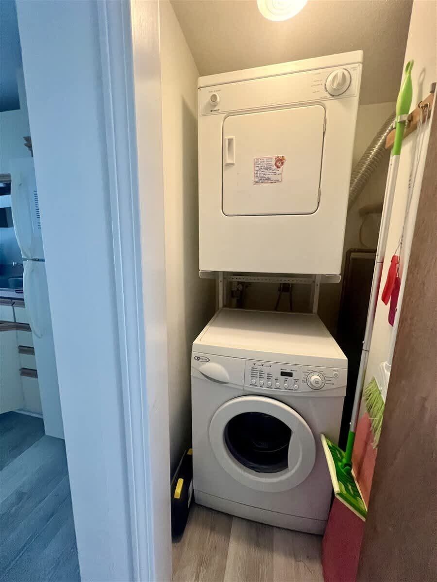 A compact laundry room with a front-loading washing machine and a stacked dryer.