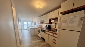 A kitchen with white cabinets, a dishwasher, and a refrigerator. - Oceanfront Wells Beach Condo - Ocean Surf #5 (Wells)