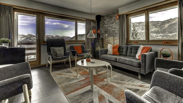 A modern living room with a sofa, chairs, a coffee table, and large windows offering mountain views. - Appartement Mont Parrain 4 - La Tzoumaz, 4 Vallees (La Tzoumaz)