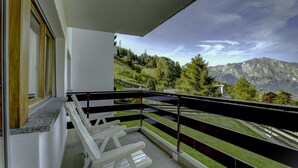 A balcony with white chairs, a view of a mountainous landscape, and a clear sky. - Appartement Mont Parrain 4 - La Tzoumaz, 4 Vallees (La Tzoumaz)