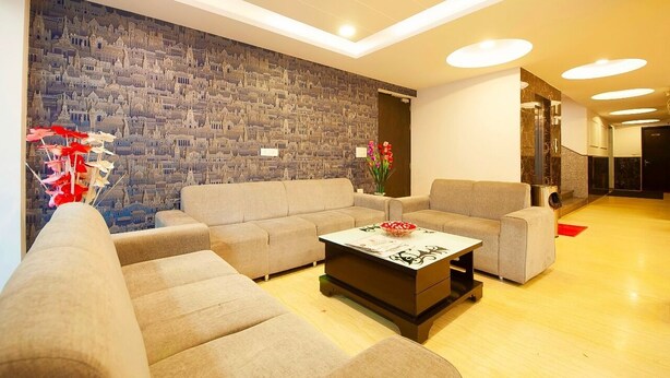 A modern living room with a cityscape mural, a sofa, a coffee table, and a vase with flowers.