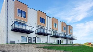 Un moderno edificio residencial de varios pisos con balcones y ventanas amplias.
