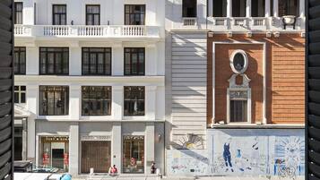Un edificio con varios pisos, balcones y una fachada con rótulos.