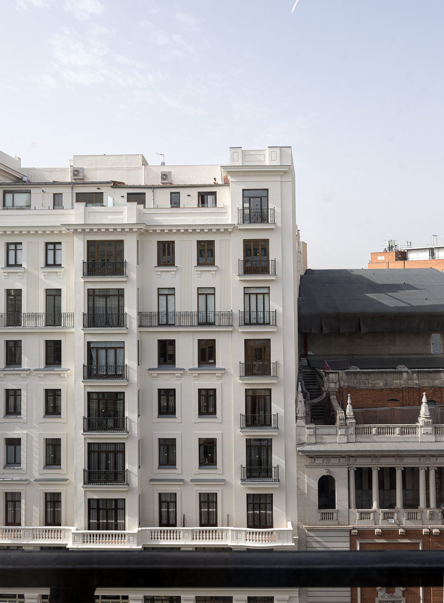 A multi-story building with a symmetrical facade, large windows, and balconies.