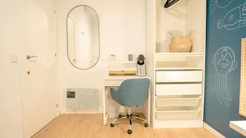 Een kamer met een bureau, stoel, planken en een spiegel.