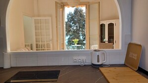 A modern kitchen with a built-in stove, a kettle, and a wooden cutting board.